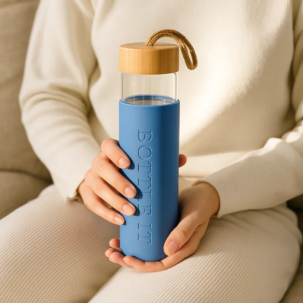 Person holding Lagoon blue reusable glass water bottle
